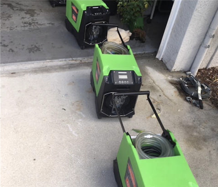 Four green air movers in a row outside. 